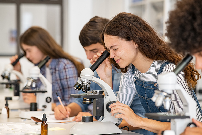 Photo: student looking through microscope